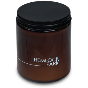 Potager Soap Co. 8 oz Lychee Mangosteen candle in an amber glass jar with a matte black metal lid