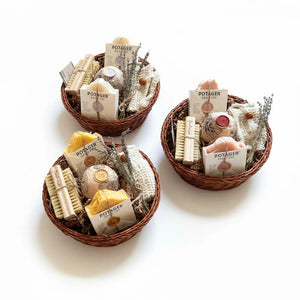 Three Potager Soap Co. artisan bath gift baskets containing natural soap bars, bamboo brushes, and dried lavender.
