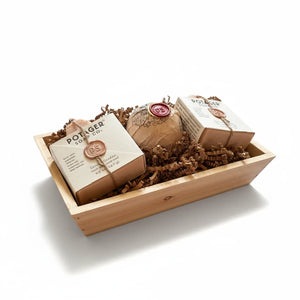 Potager Soap Co. artisan soap gift set featuring two organic soap bars and a bath bomb in a rustic wooden crate.