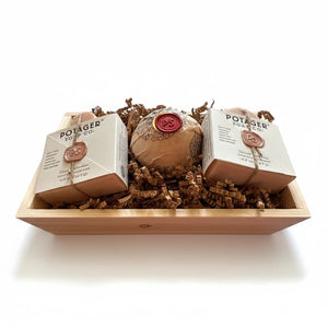 Potager Soap Co. artisan soap gift set featuring two organic soap bars and a bath bomb in a rustic wooden crate.