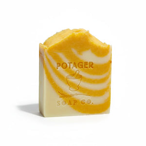 Potager Soap Co. artisan bar soap with a vibrant orange and creamy white swirl design and embossed brand logo