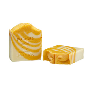 Potager Soap Co. artisan bar soap with orange and white swirls and embossed brand logo on a white background.