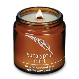 Potager Soap Co. HEMLOCK PARK eucalyptus mint coconut wax candle in an amber glass jar with a lit wood wick.