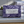 Potager Soap Co. Everyday Lavender bar soap in purple patterned paper packaging on a bathroom counter with towels.