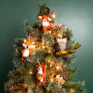 Potager Soap Co. handmade felt forest animal ornaments including deer, fox, owl, squirrel, and hedgehog on a tree.