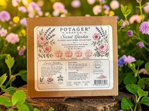 Potager Soap Co. Secret Garden flower bath bomb collection box set with botanical illustrations in a garden setting