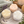Potager Soap Co. flower-shaped bath bombs in yellow, peach, and white on a marble tray with lavender and a candle.