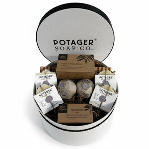 Potager Soap Co. handcrafted gift set in a white linen hat box with soaps, bath bombs, body brush, and nail brush.