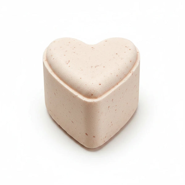 Potager Soap Co. heart-shaped botanical bath bomb in soft pink with speckled texture on a white background.