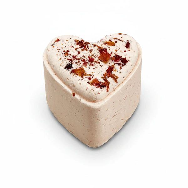 Potager Soap Co. heart-shaped bath bomb in pale pink with dried flower petals on top for a relaxing spa experience.
