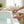 Potager Soap Co. heart-shaped lavender bath bomb with dried botanicals being placed on a white bathtub edge