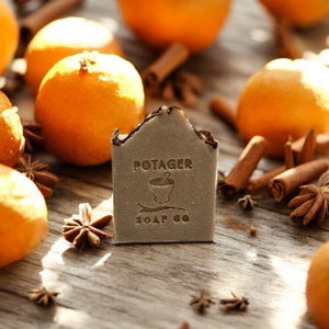 Potager Soap Co. Holiday Spice artisan soap bar featuring a rustic embossed logo surrounded by oranges and cinnamon.