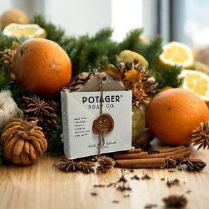 Potager Soap Co. Holiday Spice organic bar soap in white paper packaging with a wax seal, surrounded by citrus and spice