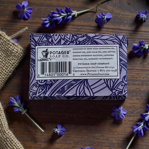 Back of Potager Soap Co. Everyday Lavender bar packaging featuring ingredients list on a wooden table with lavender