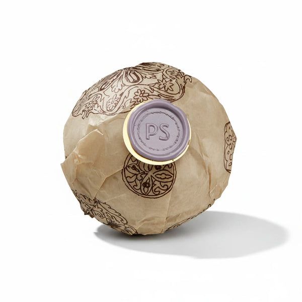 Potager Soap Co. lavender bath bomb wrapped in patterned paper with a signature purple wax seal on a white background