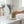 Hand holding a Potager Soap Co. lavender and patchouli botanical bar soap over a white ceramic dish in a bright bathroom