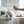 Hand spraying Potager Soap Co. French Lavender organic room and linen spray in a bright, serene bedroom setting.