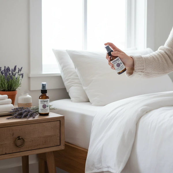 Potager Soap Co. French Lavender room and linen spray in an amber glass bottle being misted over a white bed.