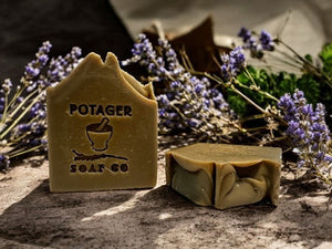 Potager Soap Co. lavender patchouli organic bar soap with a stamped logo, surrounded by dried lavender sprigs.