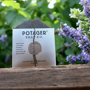 Potager Soap Co. Lavender Patchouli organic bar soap wrapped in paper with twine and a wax seal in a garden setting.