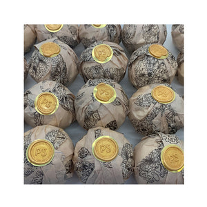 Potager Soap Co. lemongrass bath bombs wrapped in patterned paper with gold wax seals in a grid arrangement