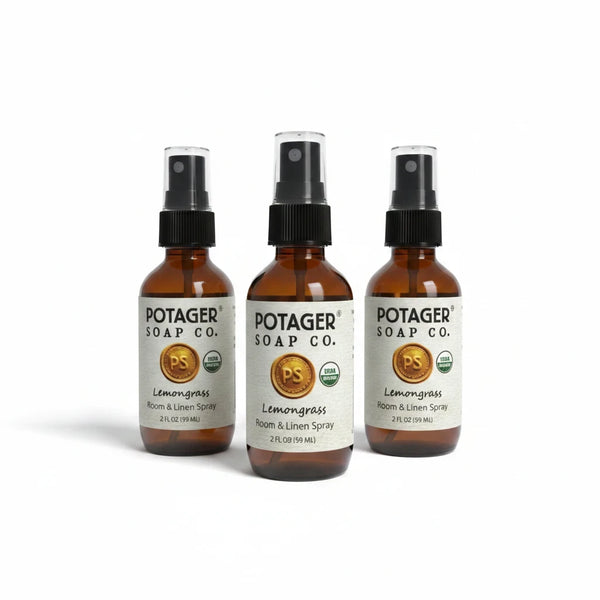 Three Potager Soap Co. amber glass bottles of organic lemongrass room and linen spray with black spray nozzles.