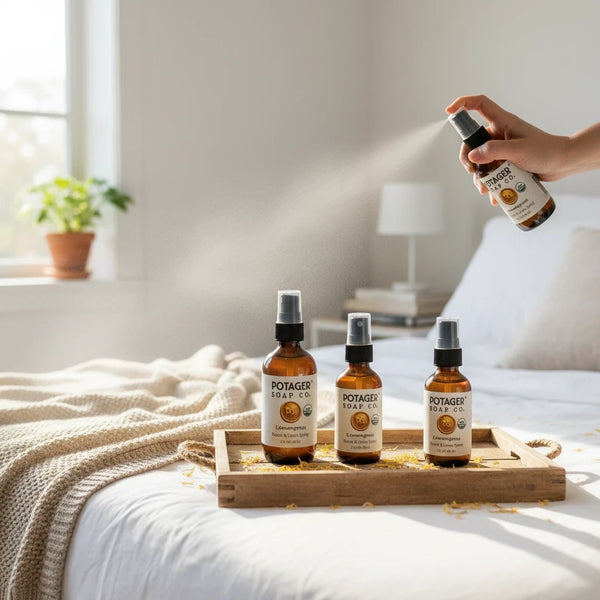 Potager Soap Co. organic lemongrass room and linen spray in amber glass bottles on a wooden tray in a bright bedroom