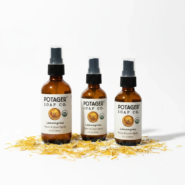 Potager Soap Co. organic lemongrass room and linen spray in amber glass bottles surrounded by dried flower petals.
