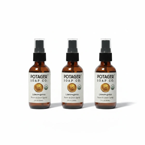 Three Potager Soap Co. Lemongrass Room and Linen Spray bottles in amber glass with black spray nozzles.