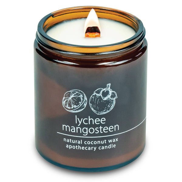 Potager Soap Co. Lychee Mangosteen candle in an amber glass jar with a lit wood wick and natural coconut wax.