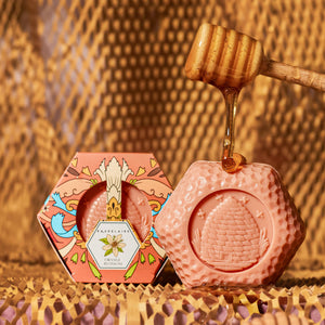 Potager Soap Co. orange blossom honey soap bar in a hexagon shape with a wooden honey dipper drizzling golden honey.