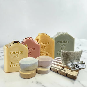 Potager Soap Co. Organic Botanical Shower Starter Kit with four soap bars, shower steamers, wooden dish, and scrub bag.