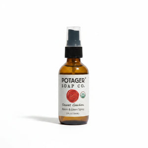Potager Soap Co. Secret Garden organic room and linen spray in a 2 oz amber glass bottle with a black spray nozzle.