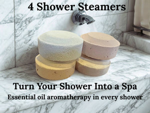 Potager Soap Co. set of four organic botanical shower steamers on a marble ledge with running water in the background.