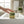 Hand holding a Potager Soap Co. rosemary lemongrass artisan soap bar with green clay swirls over a bathroom sink.
