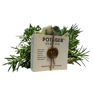 Potager Soap Co. Rosemary Lemongrass bar soap wrapped in paper with a wax seal, set against fresh rosemary sprigs.