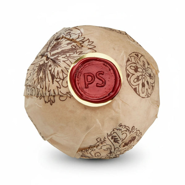 Potager Soap Co. Secret Garden bath bomb wrapped in brown paper with a red wax seal featuring PS initials.