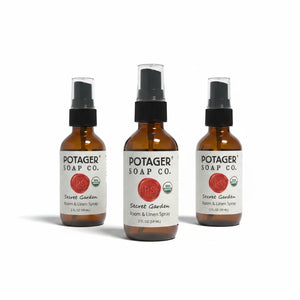 Three Potager Soap Co. Secret Garden room and linen spray bottles in amber glass with black spray nozzles.