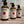 Three Potager Soap Co. Secret Garden hand and body lotion bottles in amber glass with black pump dispensers.
