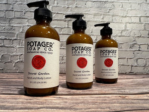 Three Potager Soap Co. Secret Garden hand and body lotion bottles in amber glass with black pump dispensers.
