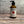 Potager Soap Co. Secret Garden hand and body lotion in an amber glass bottle with a black pump dispenser.