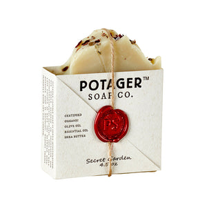 Potager Soap Co. Secret Garden organic castile soap bar with dried flower petals and a red wax seal on paper wrapping.