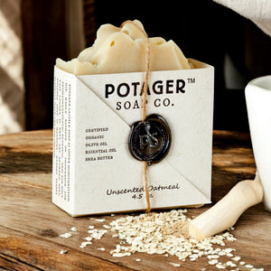 Potager Soap Co. bar of soap in a white box on a wooden surface with oats.