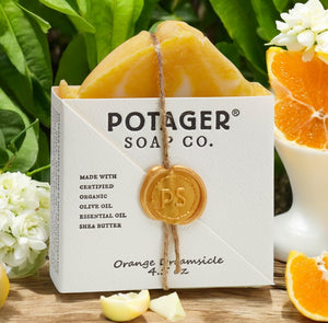 Potager Soap Co. Orange Dreamsicle soap bar with packaging surrounded by oranges and ylang ylang flowers